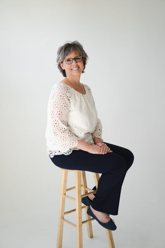Jennifer Peterson seated portrait in a white lace top