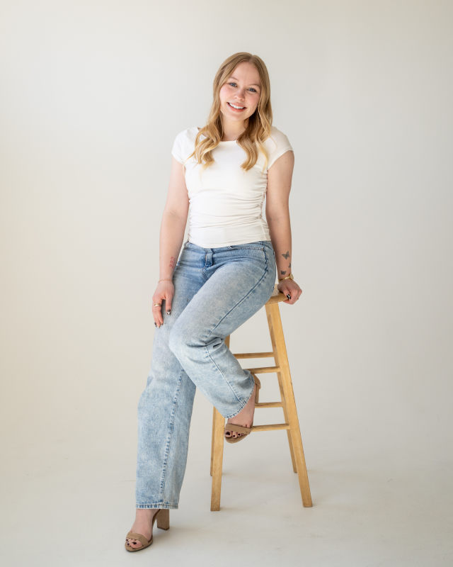 Kyra Andersen seated portrait in a white tee